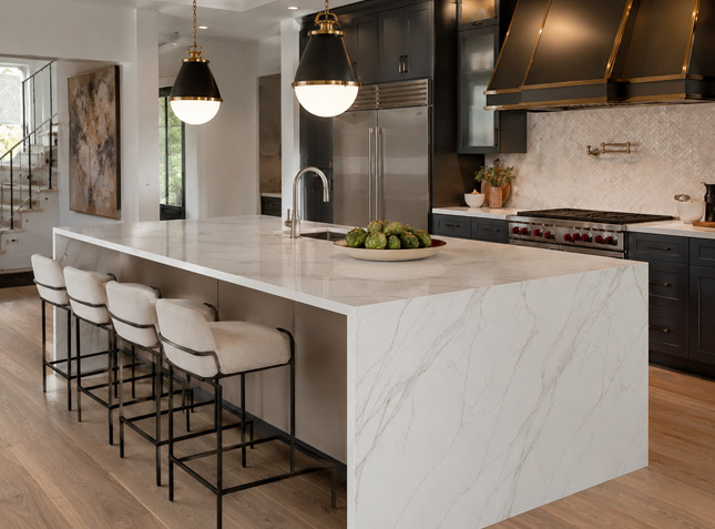 Large kitchen island with marble-look quartz countertop and waterfall edge